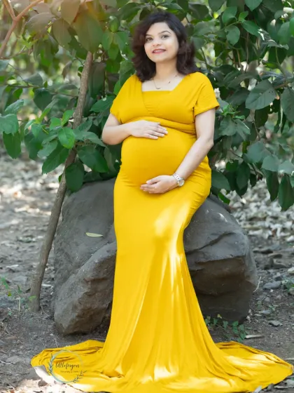 Basking in the warmth of the sun and new life. This mom-to-be in a stunning yellow gown is the picture of serenity, surrounded by the lush green of the park.