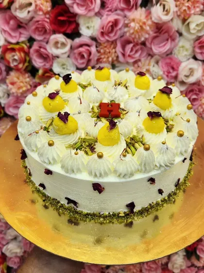 For a truly royal celebration, I recommend my Pista Rasmalai cake. It's decorated with chunks of rasmalai, chopped pistachios, and dried rose petals, offering a rich and nutty flavor profile that's both luxurious and comforting.
