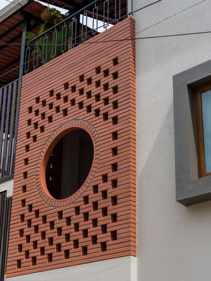 A closer look at the craftsmanship of the wire-cut brick jali. The circular cutout acts as a modern window, framing the view while the surrounding perforations create a beautiful play of light and shadow.