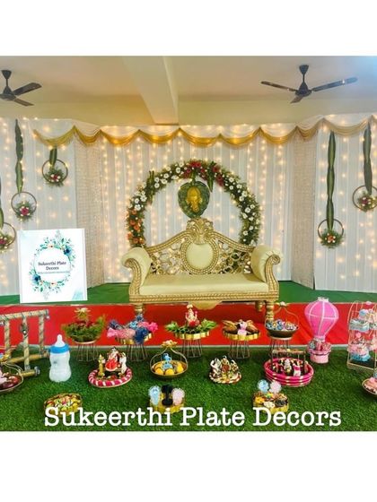 For this baby shower, I used grand brass plates to create a very traditional and royal look. The setup includes a hot air balloon prop and other custom decorations.