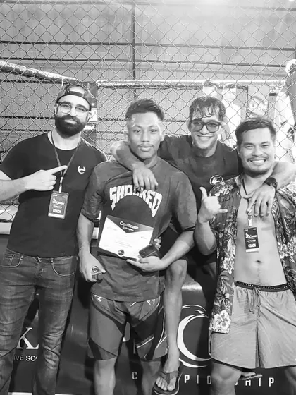 The team celebrating a win. The coaches and teammates are the backbone of any fighter's success, providing support both inside and outside the cage.
