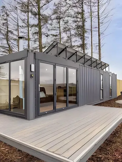 This container home is designed for energy efficiency, with solar panels installed on the roof. The large deck and glass facade make it an ideal choice for sustainable, modern living.