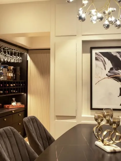 This dining and bar area in a 700 sq ft living space features a hidden bar, a detail I love for its space-saving functionality and surprise element. The black finish of the bar adds a touch of sophistication.