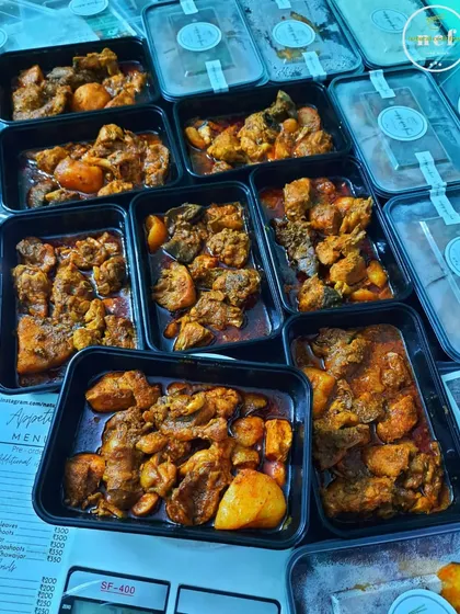 Chicken curry and other items being weighed and packed for delivery.