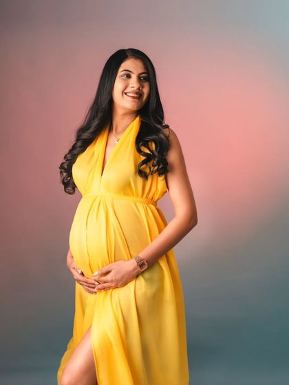 This mom-to-be is absolutely glowing. A simple, happy portrait against a colorful studio backdrop, her yellow gown brings so much warmth and energy to the photo.