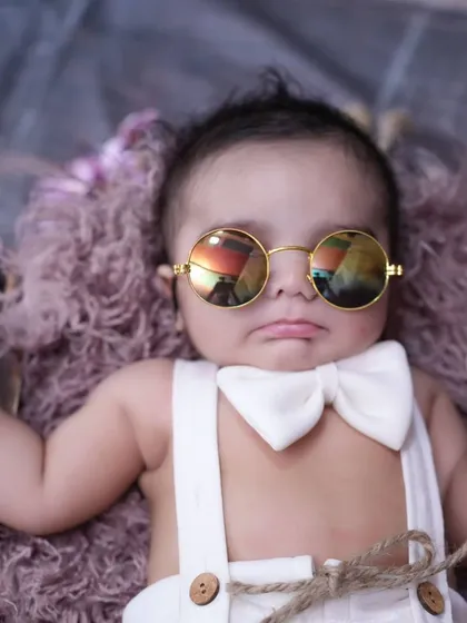 This cool little dude is ready for his close-up. A newborn styled with sunglasses and a bow tie shows that even the tiniest babies can have a big personality.