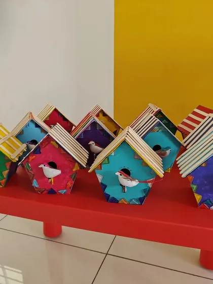 A flock of colorful, hand-painted birdhouses ready to go home after an artsy birthday party. Each child gets to express their unique style, making every creation special.