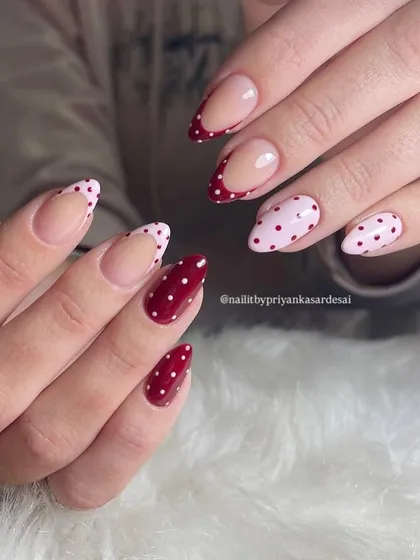 Spotted: the cutest nails in town. A playful mix of red and pink polka dot nails, including some with a French tip design for a modern twist.