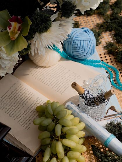 The little details that make a theme come to life: an open book, fresh grapes, and spools of yarn in the event's color palette.