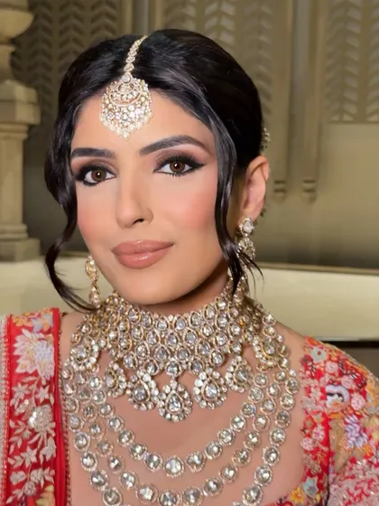 Another angle of this beautiful bride, highlighting the harmony between the makeup, the magnificent layered necklace, and the elegant maang tikka.