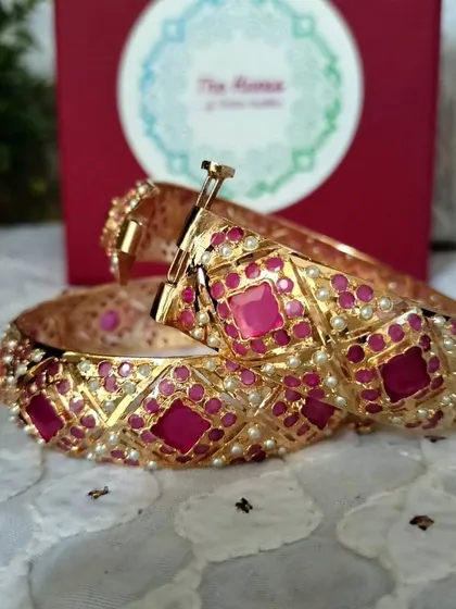 The 'रानी' (Rani) gold-plated Jadau bangles. The ruby-red stones give these openable bangles a rich, royal look.
