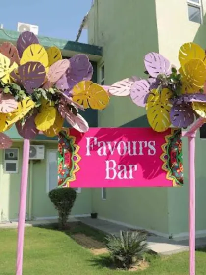 A bright and fun "Favours Bar" sign, adding a playful and interactive element to the Haldi or Mehndi function.