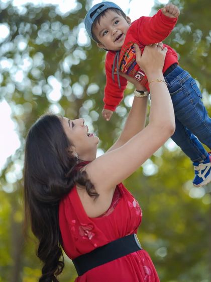 Pure happiness in a mother's arms. This candid outdoor shot captures a beautiful, spontaneous moment of joy between a mother and her son.