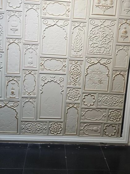 A traditional Indian-themed feature wall with multiple carved panels, creating a rich tapestry of cultural motifs.