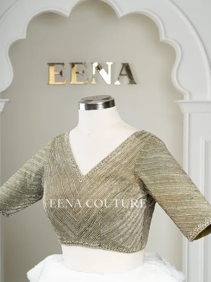 I designed this sage green raw silk blouse with geometric handwork for a timeless yet modern feel. The linear beadwork is complemented by custom floral tassels, making it a versatile piece for any occasion.