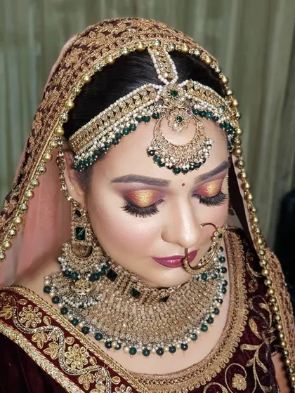 This is my signature bridal makeup style. It features a warm, sunset-toned halo eye, perfectly defined brows, and a flawless base. This look is paired with heavy emerald and gold jewelry for a truly royal effect.