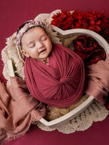 A sleeping rose. This baby's sweet, sleepy smile is the centerpiece of this lovely, romantic setup.