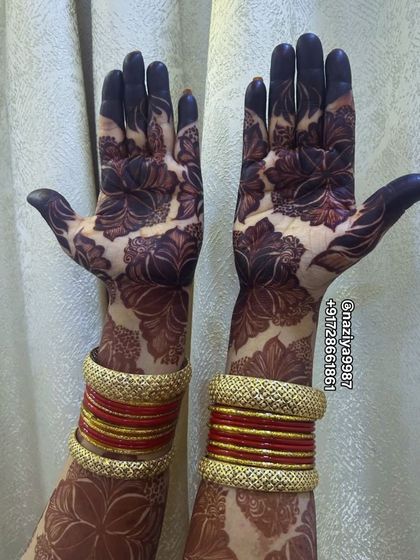 The beautiful dark stain of a floral design, complemented by bridal bangles.