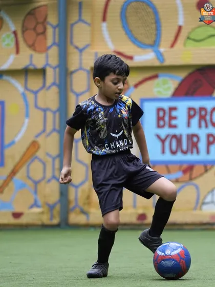 A young player practices his ball mastery, using the sole of his foot to control the ball.