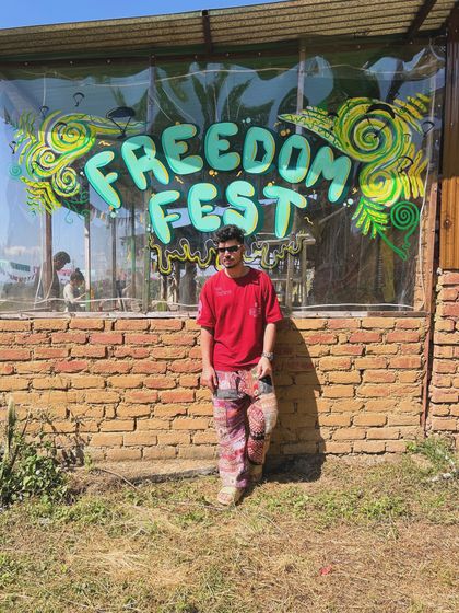 Taking a moment before my set at Freedom Fest. The brick and graffiti backdrop captures the raw, artistic vibe of the event.