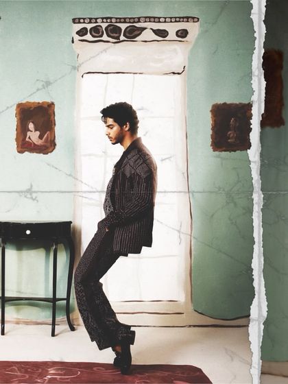 An artistic, full-length shot of Ishaan Khatter from the Bridal Asia editorial. The makeup is subtle, designed to look natural while still defining his features for the camera.