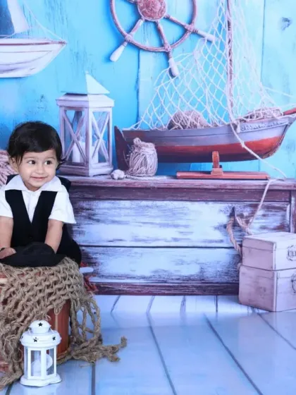 A smiling baby boy sits amidst a sea of nautical props. The attention to detail in this sailor theme makes for stunning and imaginative portraits.