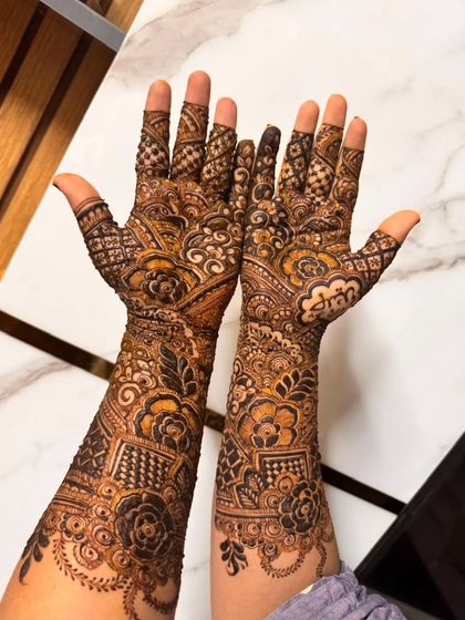 Another shot of this intricate bridal henna, showcasing the fine lines and detailed patterns that cover the hands and arms.