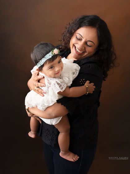 A mother and her eight-month-old daughter share a moment of pure joy. The baby's smile and the mother's laughter make this a truly heartwarming portrait.