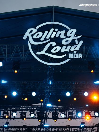 A crisp shot of the iconic "Rolling Loud India" logo high above the stage rigging. This image sets the scene and establishes the massive scale of the event.