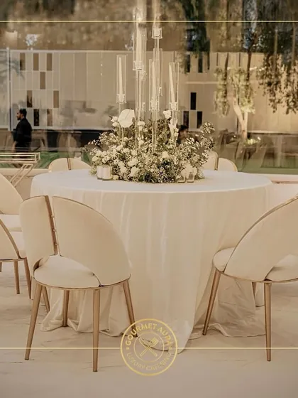 A beautifully set round table with a floral centerpiece, ready for guests at an elegant outdoor event. Our service ensures a flawless dining experience from start to finish.