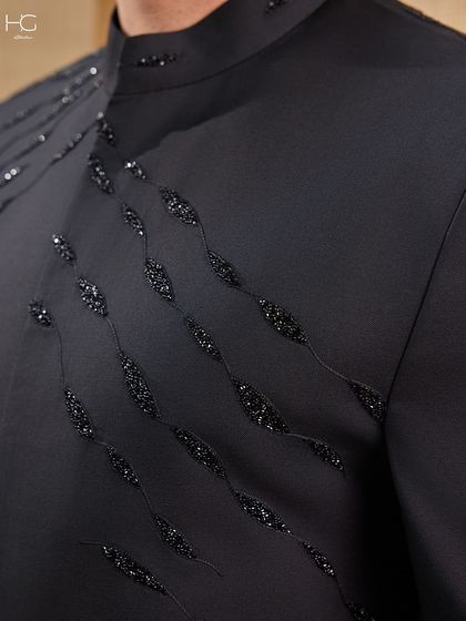 A macro view of the beadwork on the embroidered Achkan. Each bead is hand-stitched to create a flowing pattern that provides texture and a touch of understated opulence.