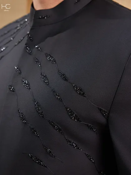 A macro view of the beadwork on the embroidered Achkan. Each bead is hand-stitched to create a flowing pattern that provides texture and a touch of understated opulence.