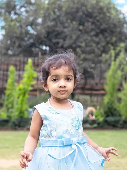 A close-up portrait of a little girl during an outdoor family shoot. The natural background and soft light create a beautiful, classic look.