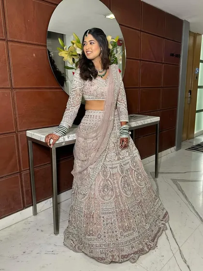 A full view of this dreamy and elegant soft glam bridal look. The intricate silver work on the lehenga is balanced with subtle makeup, creating a look of timeless beauty.