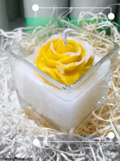A rose that never wilts. This yellow rose candle, delicately hand-poured and blooming with charm, is set in a square glass jar.