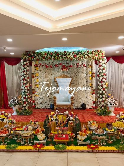 A divine baby shower setup with a backdrop of white flowers and a full display of traditional plates, creating a pure and serene ambiance.