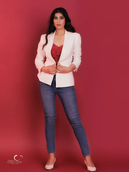 A powerful, fashion-forward stance. The way she holds her blazer exudes confidence and a sense of being in control.