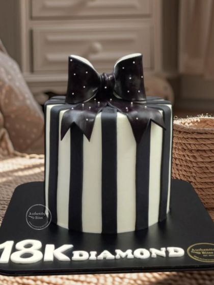 A chic black and white striped gift box cake. The bold stripes and polka-dotted bow make for a very stylish party cake.