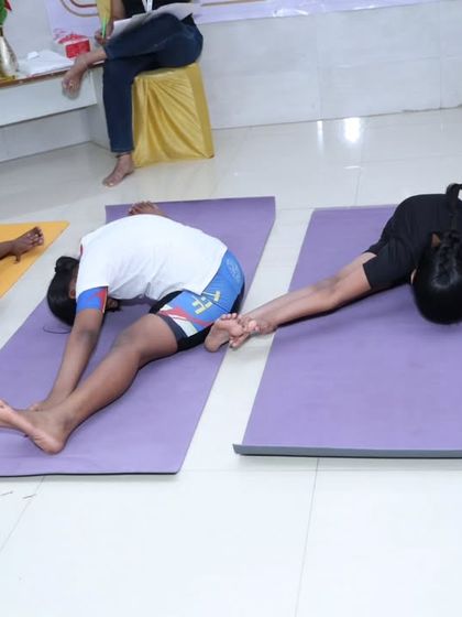 Young competitors demonstrating deep forward bends like Paschimottanasana (Seated Forward Bend) during the children's yogasana championship. Their flexibility and dedication at such a young age are remarkable.