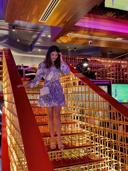 Descending the stairs, this shot gives a better view of the dress's print and silhouette. It's a great example of a one-and-done piece that makes a statement.