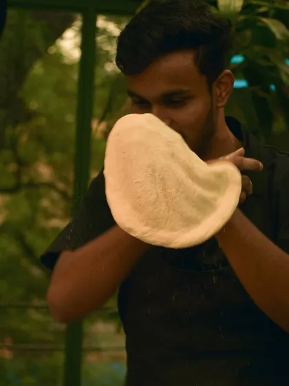 A member of my team expertly stretching dough for our flatbreads. The quality of the bread is just as important as the toppings.