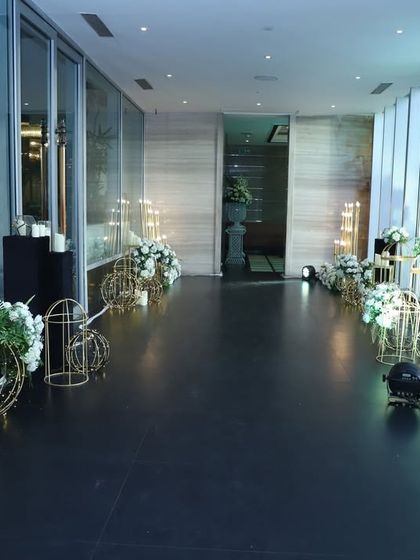 A modern and minimalist walkway lined with golden birdcage-style lanterns and white florals. This design creates a clean and elegant path, perfect for a contemporary event.
