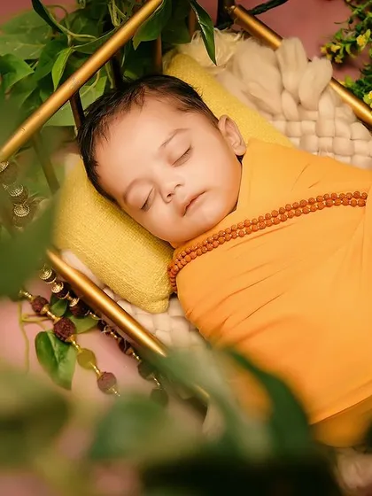 A beautifully framed close-up of the baby during the "Jai Shree Ram" shoot, capturing a peaceful moment amidst the greenery.