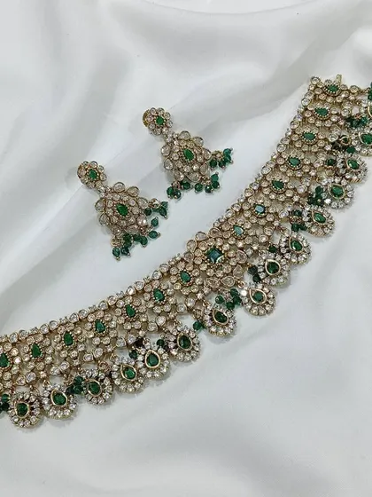 Our elegant choker sets are perfect for mixing and matching. This piece, featuring high quality white and green stones in a floral design, comes with matching earrings and can elevate any festive or party outfit.