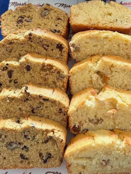 A beautiful display of my assorted tea cake slices. On the left, a coffee and walnut loaf, and on the right, a kaju and raisin loaf, showing the rich texture and ingredients in every slice.
