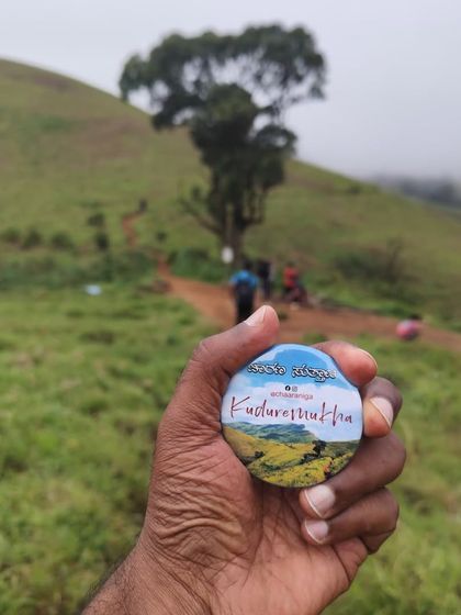 Holding up the Kudremukha trek badge against the backdrop of the famous lone tree on the trail. A memory to take back home.