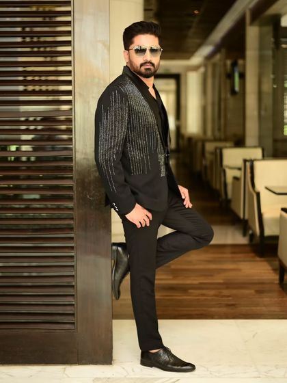 Another stylish pose in our black sequin blazer. It's a go-to piece for any man who wants to add some sparkle to his wardrobe.