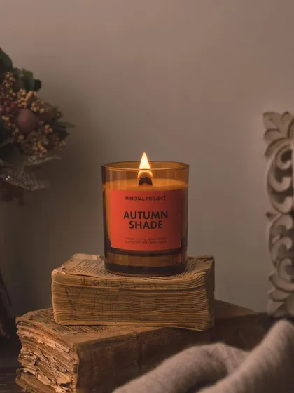A classic still life for a candle, styled on a stack of old books. This creates a vintage, scholarly aesthetic, perfect for a quiet evening of reading.