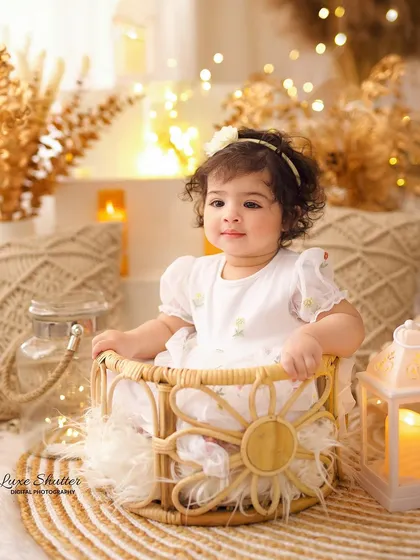 A curious and sweet expression from the birthday girl in our boho basket prop, surrounded by the warm glow of fairy lights.