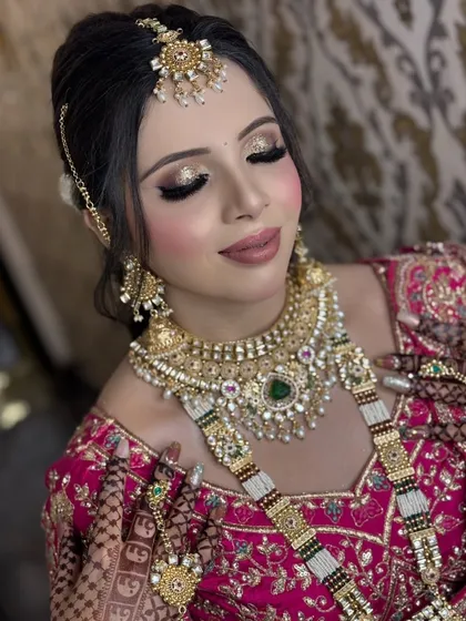 A close-up of a regal bridal makeup look. Notice the detailed golden glitter on the eyelids, the perfectly blended skin, and the way the makeup complements the heavy Polki jewellery. This is the level of detail and precision I bring to every client.